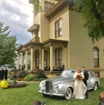 Happy couple standing in front of The Pepin Mansion next to a vintage Rolls Royce